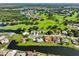 Aerial view of a community surrounded by a lush green golf course, a serene lake and many houses at 2110 W View Dr, Sun City Center, FL 33573