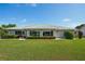 Lush green backyard featuring a well-manicured lawn and a beautiful arrangement of plants at 2110 W View Dr, Sun City Center, FL 33573