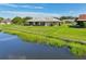 Home overlooking a tranquil pond, featuring a well-maintained lawn and beautiful landscaping at 2110 W View Dr, Sun City Center, FL 33573
