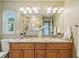Bathroom featuring double sink with granite countertop and decorative lighting at 2110 W View Dr, Sun City Center, FL 33573