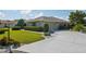 Single-story home with a well manicured lawn, bushes, and mature trees at 2110 W View Dr, Sun City Center, FL 33573
