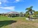 Well-maintained home with lush lawn, manicured hedges, and a palm tree in the front yard at 2110 W View Dr, Sun City Center, FL 33573