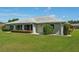 Home with well-kept lawn, manicured shrubs, and a gray roof under a clear blue sky at 2110 W View Dr, Sun City Center, FL 33573