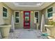 Inviting front entrance with a decorative red door, potted plants, and decorative stones at 2110 W View Dr, Sun City Center, FL 33573