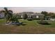 This lovely home features a manicured lawn and a palm tree in a peaceful residential neighborhood at 2110 W View Dr, Sun City Center, FL 33573