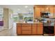 Bright kitchen with wooden cabinets, granite countertops, and stainless steel appliances, offering a blend of functionality and style at 2110 W View Dr, Sun City Center, FL 33573