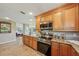 Modern kitchen featuring stainless steel appliances, wood cabinets, and granite countertops, seamlessly blending style with functionality at 2110 W View Dr, Sun City Center, FL 33573