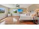 Bright main bedroom features wood floors, ceiling fan, and coordinated white furniture and decor at 2110 W View Dr, Sun City Center, FL 33573