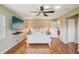 Well-lit main bedroom features wood floors, a ceiling fan, and white furniture with neutral walls at 2110 W View Dr, Sun City Center, FL 33573