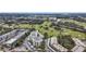 Expansive aerial view of a condo complex situated adjacent to a lush green golf course and serene lakes at 225 Country Club Dr # 1506, Largo, FL 33771