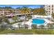 View of the community pool area with lounge seating, palm trees, and a white fence for privacy and security at 225 Country Club Dr # 1506, Largo, FL 33771