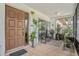 Inviting covered front porch with tiled flooring, plants, and a decorative front door at 2270 Spruce Ln # B, Palm Harbor, FL 34684
