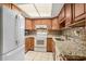 Functional kitchen with white appliances, granite countertops, and ample cabinet space at 2270 Spruce Ln # B, Palm Harbor, FL 34684