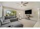 Comfortable living room features a large sectional sofa, neutral carpeting, and an updated ceiling fan at 2270 Spruce Ln # B, Palm Harbor, FL 34684