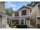 Charming two-story townhouse with tan siding, black shutters, covered entry, and landscaped front yard at 2377 Hounds Trl, Palm Harbor, FL 34683