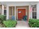 Cozy front porch with blue chairs, decorative touches, and a welcoming entrance to the home at 2377 Hounds Trl, Palm Harbor, FL 34683