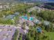 Beautiful aerial view of the community pool, tennis courts, clubhouse, and parking at 26835 Juniper Bay Dr, Wesley Chapel, FL 33544