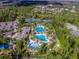 An aerial view of a pool and recreational center with tennis courts, landscaping, and blue skies at 26835 Juniper Bay Dr, Wesley Chapel, FL 33544