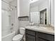 Cozy bathroom with a combined shower and tub, a dark vanity, and a decorative shelf at 26835 Juniper Bay Dr, Wesley Chapel, FL 33544