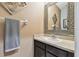 Elegant bathroom features a modern sink with stone countertops and a decorative framed mirror at 26835 Juniper Bay Dr, Wesley Chapel, FL 33544
