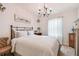 Charming bedroom with a metal bed frame, a chandelier, and soft natural light from the window at 26835 Juniper Bay Dr, Wesley Chapel, FL 33544