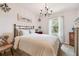 Bedroom with an antique bronze metal bed frame, two dressers, decor lighting and a window with natural lighting at 26835 Juniper Bay Dr, Wesley Chapel, FL 33544