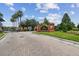 The entrance to Lakeside features a brick entrance, gate, and lush trees and landscaping at 26835 Juniper Bay Dr, Wesley Chapel, FL 33544