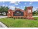 Brick Lakeside entrance sign with green landscaping against a bright blue sky with scattered clouds at 26835 Juniper Bay Dr, Wesley Chapel, FL 33544