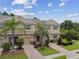 Charming townhome featuring a well-maintained front yard with tropical landscaping and brick driveway at 26835 Juniper Bay Dr, Wesley Chapel, FL 33544