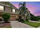 Exterior elevation of a two story home with a well manicured lawn and a large palm tree at 26835 Juniper Bay Dr, Wesley Chapel, FL 33544