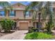 Charming townhome with a one-car garage, brick driveway, and lush landscaping at 26835 Juniper Bay Dr, Wesley Chapel, FL 33544