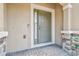 A tan home's front door with stone columns, a Ring doorbell, and decorative plants, creating a welcoming entrance at 26835 Juniper Bay Dr, Wesley Chapel, FL 33544