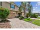 Exterior view of a two-story home with a well-manicured lawn, landscaping, and a paved driveway at 26835 Juniper Bay Dr, Wesley Chapel, FL 33544