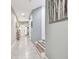 Inviting hallway featuring tile flooring and a staircase with wooden steps, leading to various rooms in the home at 26835 Juniper Bay Dr, Wesley Chapel, FL 33544