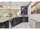 This kitchen has granite counters, dark wood cabinets, stainless dishwasher, and views to the living area at 26835 Juniper Bay Dr, Wesley Chapel, FL 33544