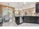 Modern kitchen with granite countertop island, stainless steel dishwasher, and view to the living room and dining area at 26835 Juniper Bay Dr, Wesley Chapel, FL 33544