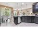 Open concept kitchen features island with seating, stainless dishwasher, and views to the lanai at 26835 Juniper Bay Dr, Wesley Chapel, FL 33544