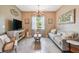 Stylish living room with neutral tones, a chandelier, a decorative art piece, and comfortable seating arrangements at 26835 Juniper Bay Dr, Wesley Chapel, FL 33544