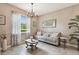 Cozy living room featuring a comfortable sofa, elegant chandelier, and natural light at 26835 Juniper Bay Dr, Wesley Chapel, FL 33544