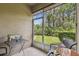 Screened in patio with outdoor furniture overlooking a beautiful green landscaped yard and blue skies at 26835 Juniper Bay Dr, Wesley Chapel, FL 33544