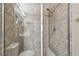 Modern shower with glass doors, a rainfall showerhead, and decorative tile accents at 26835 Juniper Bay Dr, Wesley Chapel, FL 33544