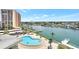 Aerial view of a pool and waterfront community with docks and boats on a sunny day at 31 Island Way # 406, Clearwater Beach, FL 33767