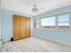 Bright bedroom featuring wood-look flooring, blue walls, a Murphy bed, and a large window with neighborhood views at 31 Island Way # 406, Clearwater Beach, FL 33767