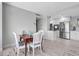 Dining area with an adjacent, updated kitchen featuring modern stainless steel appliances and tile floors at 31 Island Way # 406, Clearwater Beach, FL 33767