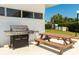 Exterior grill with a wooden picnic table under a covered patio at 31 Island Way # 406, Clearwater Beach, FL 33767