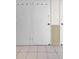 Hallway showcasing tiled flooring and white doors with black hardware for storage units at 31 Island Way # 406, Clearwater Beach, FL 33767