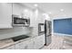 Updated kitchen featuring stainless steel appliances, white cabinets, and granite countertops at 31 Island Way # 406, Clearwater Beach, FL 33767