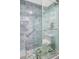 Stylish walk-in shower with designer blue brick tile, pebble floor, and safety grab bars in a luxury bathroom at 31 Island Way # 406, Clearwater Beach, FL 33767