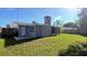 Spacious backyard view featuring a grassy area and partially fenced yard under a bright blue sky at 3150 Beacon Square Dr, Holiday, FL 34691