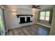 Cozy living room featuring a brick fireplace, wood floors, and natural light at 3150 Beacon Square Dr, Holiday, FL 34691